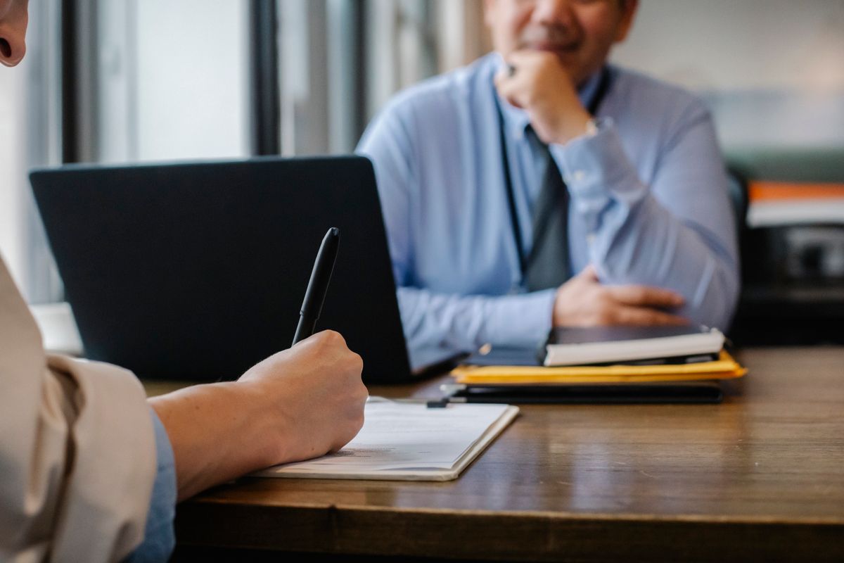 Échange entre un conseiller Cliweb et un dirigeant d'entreprise autour d'un ordinateur portable