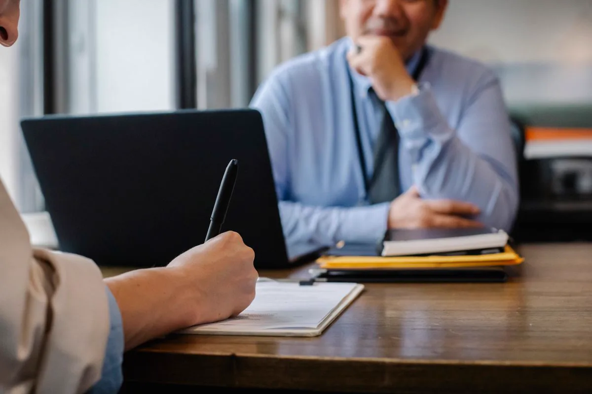 Échange entre un conseiller Cliweb et un dirigeant d'entreprise autour d'un ordinateur portable